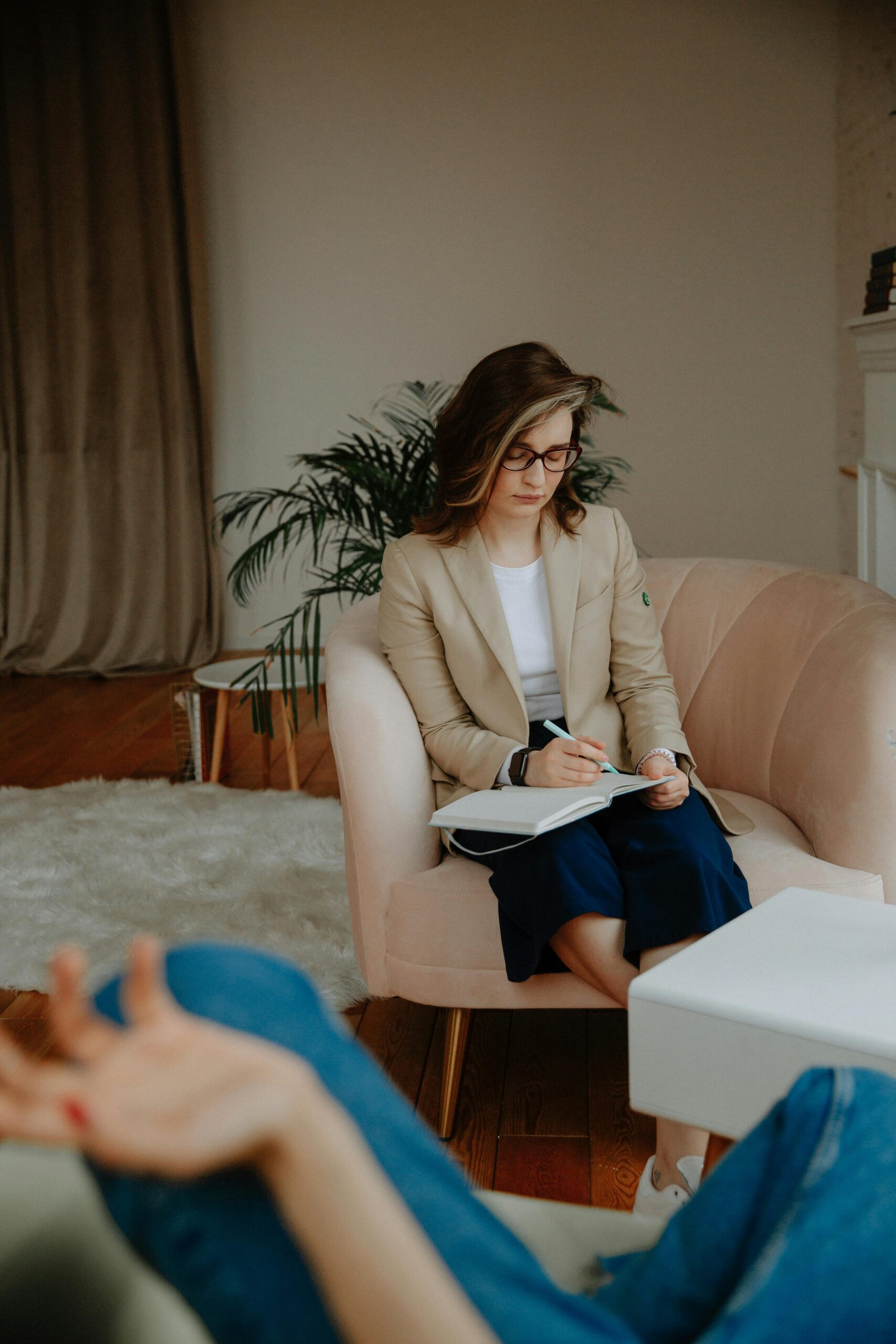 A professional woman taking notes while treating someone in OTP session.
